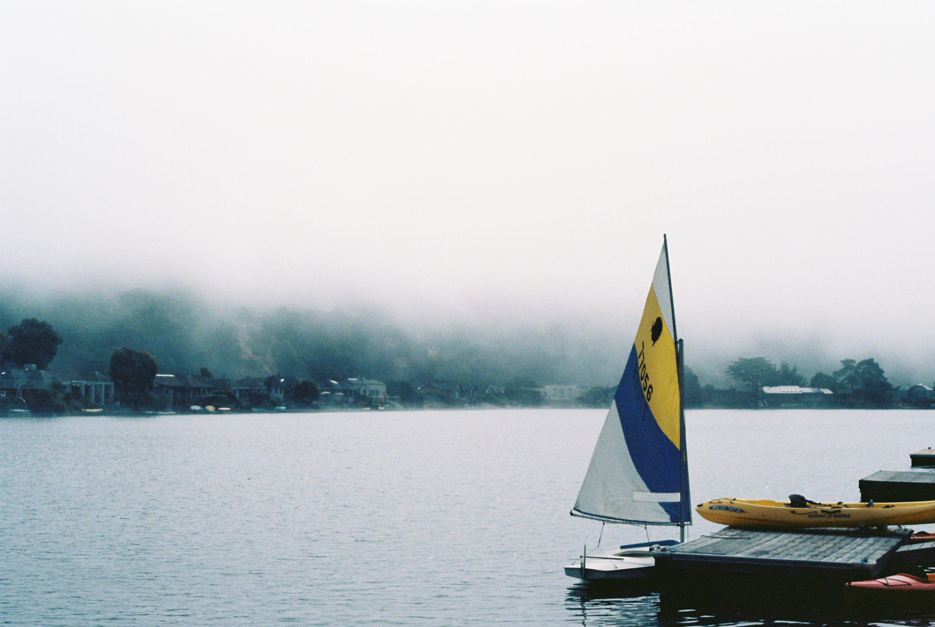 Color photo of a boat at a dock in the fog.