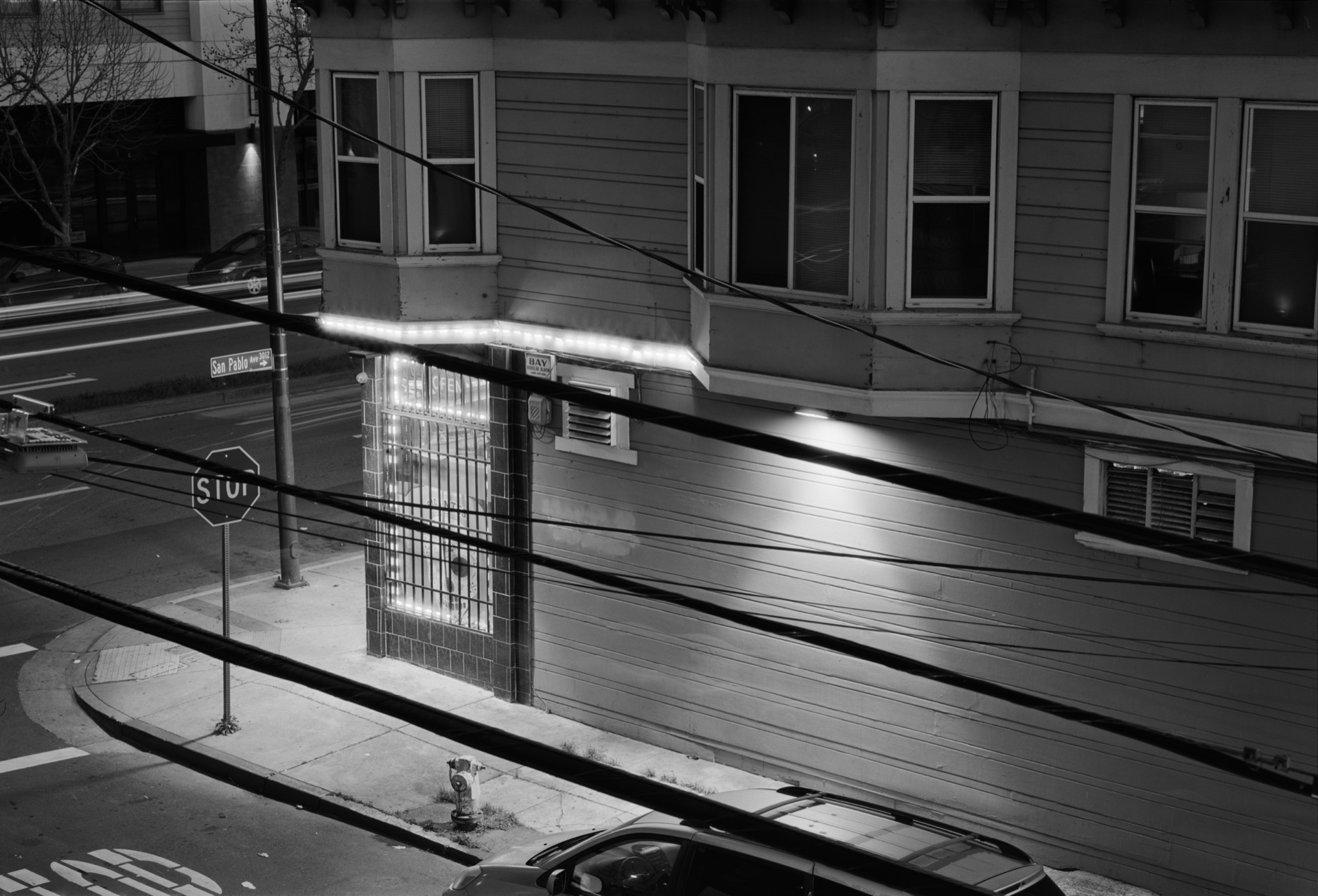 Black and white photo of a corner store at dusk